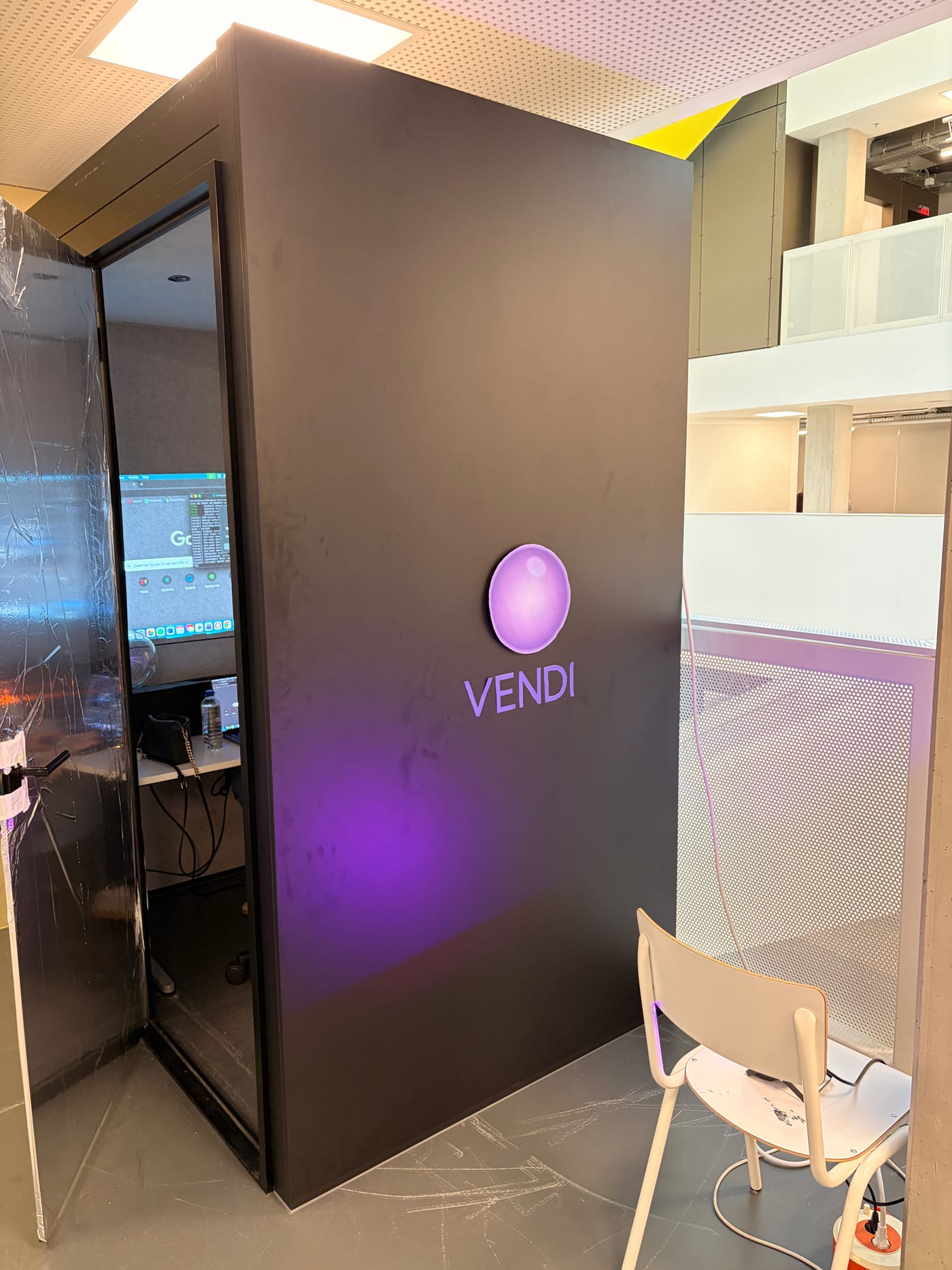 After: the same booth turned into Vendi, with the glowing orb and VENDI wordmark on its side and the door open on the interior.