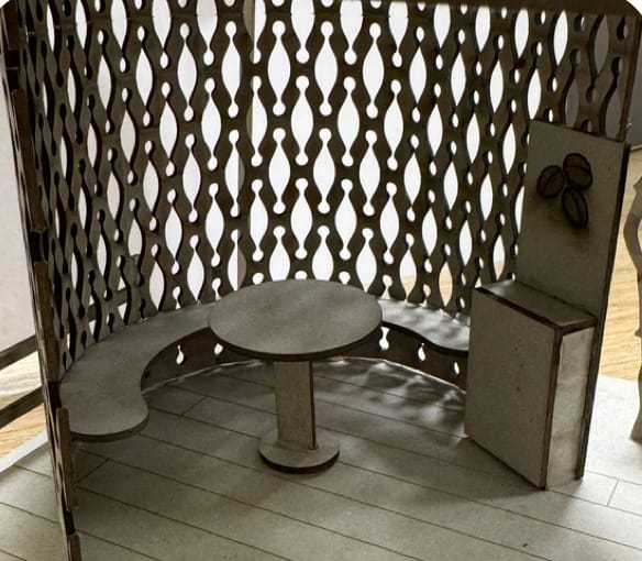 Scale model: a curved bench and table inside the perforated wall.