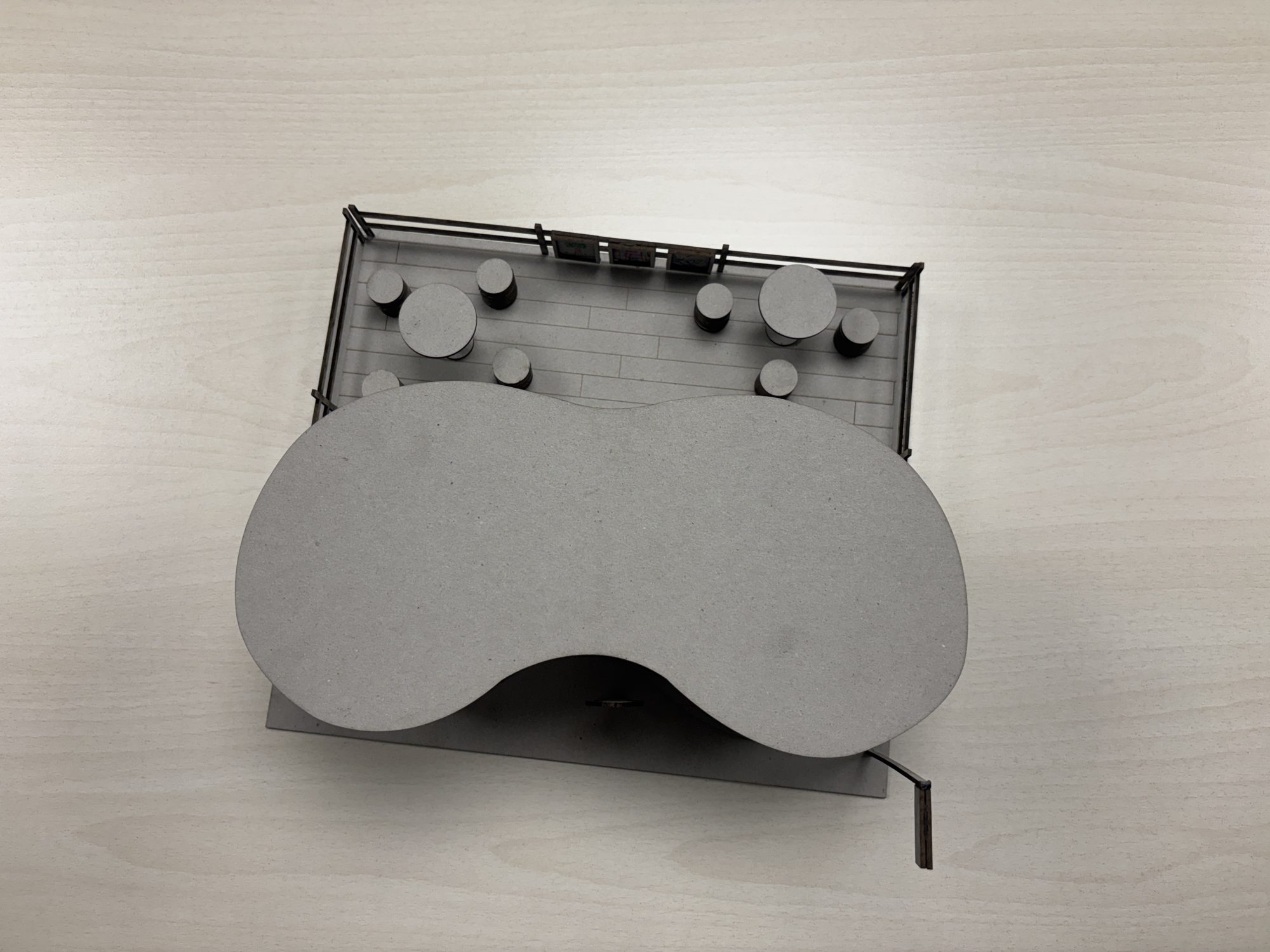 Scale model seen from above: the rounded roof and the seating area beside it.